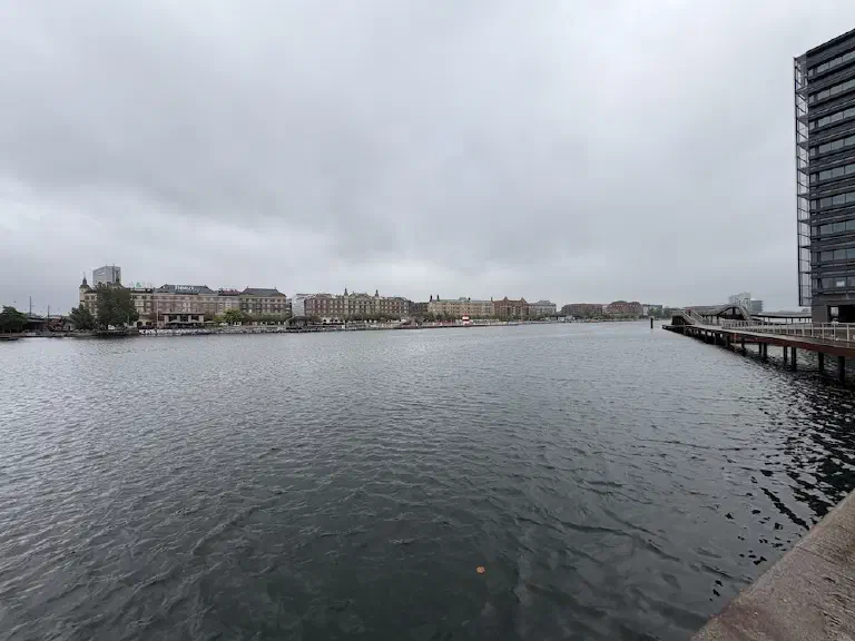 Blick über das Hafenbecken von Kopenhagen auf historische Häuserzeilen an einem grauen, bewölkten Tag