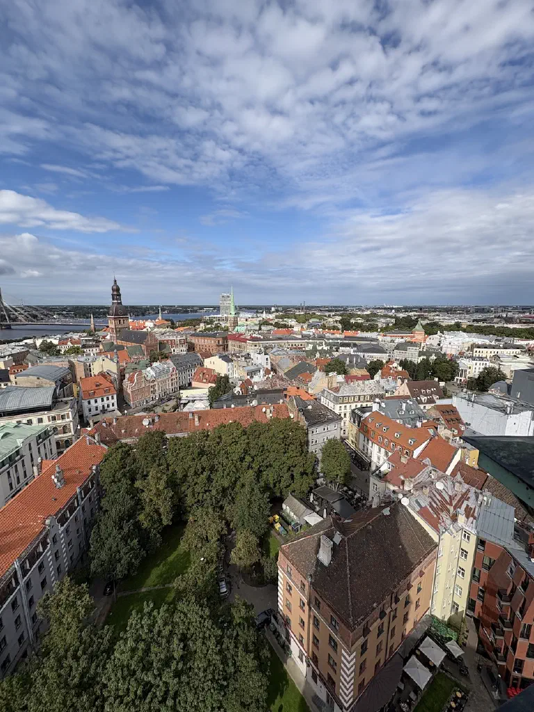 Blick von oben über die roten Dächer der Rigaer Altstadt mit Kirchtürmen und der Düna im Hintergrund